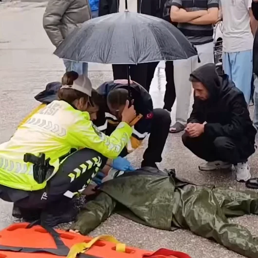 Trafik polisinden yağmur altında duyarlı davranış: Sağlık ekipleri gelene yaralı gencin başında durdu
