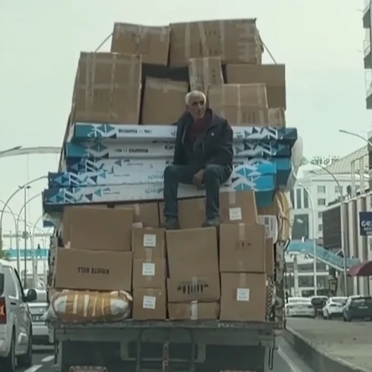 Kolilerin üzerinde oturarak seyahat etti