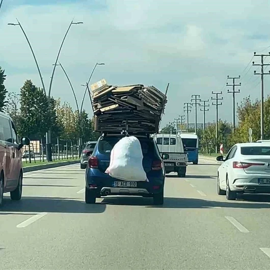 Bursa’da otomobilin üzerine yüklediği kartonlarla trafikte ilerledi
